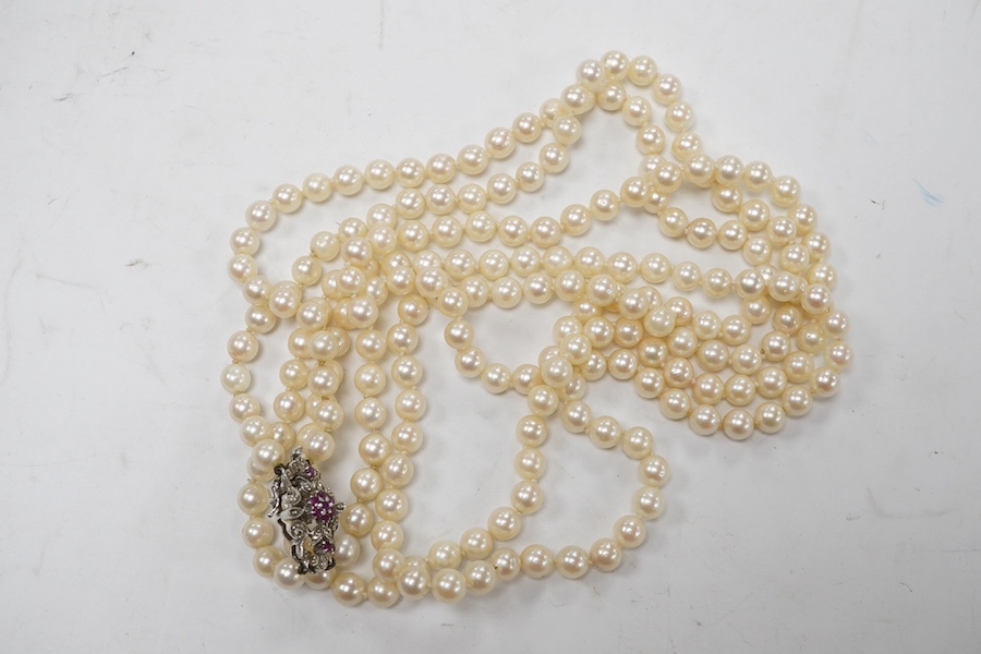 A modern double strand cultured pearl necklace, with ruby cluster set 750 white metal clasp. Condition - poor to fair